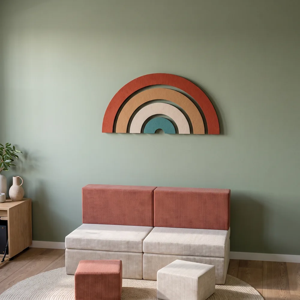 Mehrfarbiger Regenbogen aus Wollfilz als Wanddeko im Kinderzimmer, davor Spielbausteine aus Schaumstoff